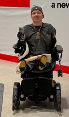 A person in a wheelchair using a tablet.